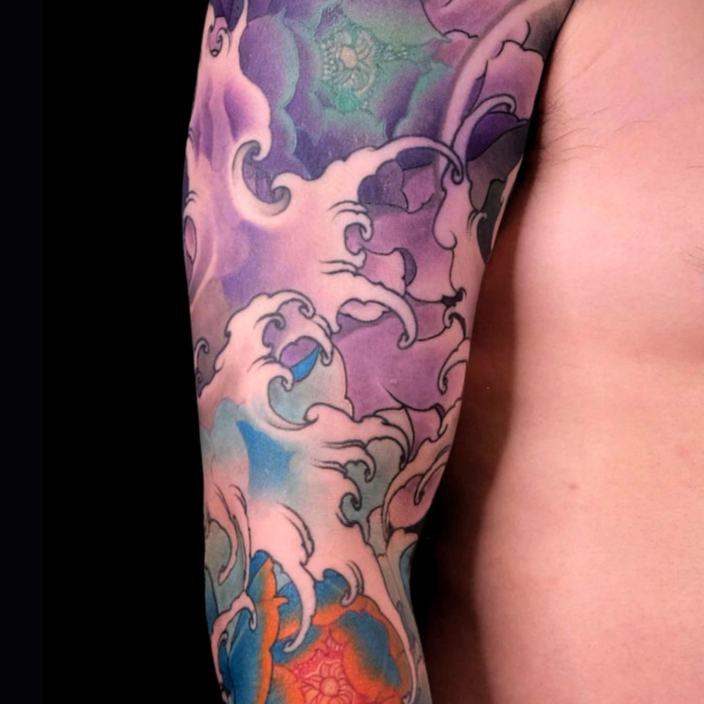 Japanese botan peony full sleeve tattoo in purple and blue with crashing waves by CK Tattoo Singapore