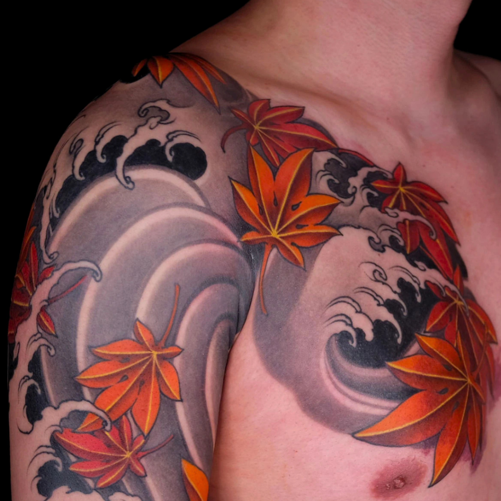 Japanese traditional momiji (autumn maple leaves) shoulder and chest tattoo with classic black and grey crashing waves. Floral irezumi by CK Tattoo, Singapore.