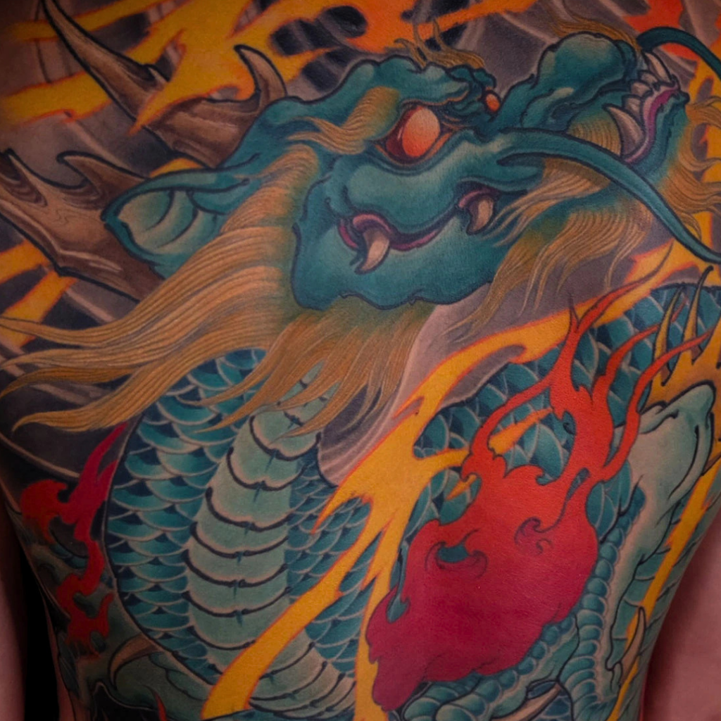 Japanese teal dragon back tattoo with flaming pearl golden mane and orange flames by CK Tattoo Singapore