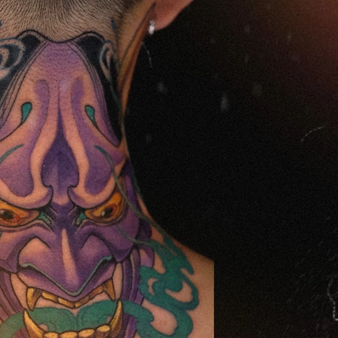 Purple Japanese Hannya mask tattoo on the back of the neck with gold horns and teal smoke, symbolizing passion, jealousy, and transformation. Artwork by CK Tattoo Singapore.
